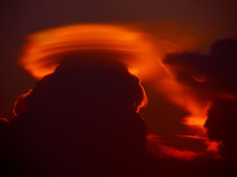 夕焼けに照らされて不気味でありながら美しい頭巾雲の写真